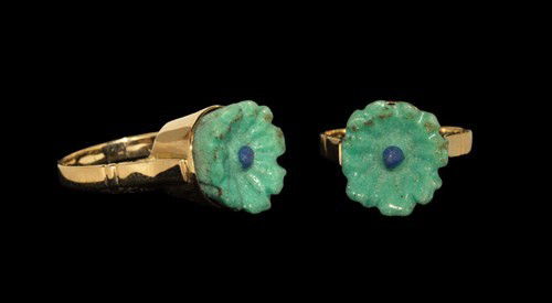 Egyptian Rosette In Gold Ring: Romano-Egyptian Period, circa 30 BC-323 AD. A turquoise faience rosette with blue centre set into a modern gold finger ring with flat-section hoop and conical bezel. Gold and faience, 3.84 grams, 27 m
