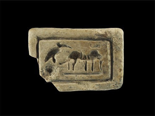 Egyptian Alabaster Stamp Seal: New Kingdom, circa 1550-1070 BC. A carved alabaster stamp seal with rectangular face depicting a quadruped facing left with a crane to its rear perched on a rock. Alabaster, 65 grams, 59 mm. Ex Terenc