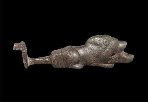 Roman Bronze Lion Key: Circa 2nd-3rd century AD. A cast bronze key with short square-section shank and thick flanged bit; the handle formed as a recumbent lion with open mouth pierced to accept a suspension ring. Bronze, 18