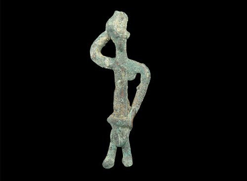 Near Eastern South Arabian Bronze Figure: Circa 1st millennium BC. A cast bronze figure of a man with one hand raised to his head and the other on his hip, wearing a loincloth. Bronze, 9 grams, 51 mm. Ex Terence Eva collection, London, UK; fo
