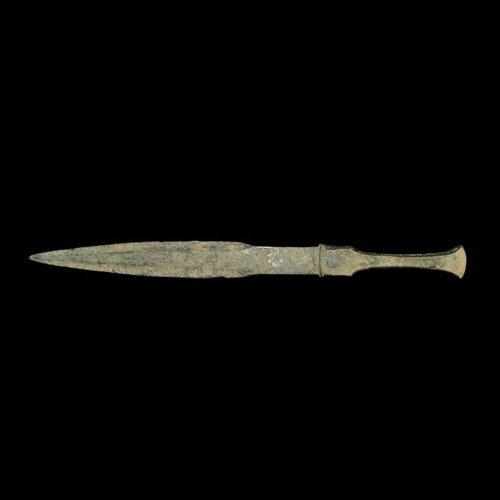 Bronze Age Luristan Dagger: Circa 12th-8th century B.C. A cast bronze dagger with flanged hilt and lanceolate blade with flat central rib. Bronze, 215 grams, 37 cm.