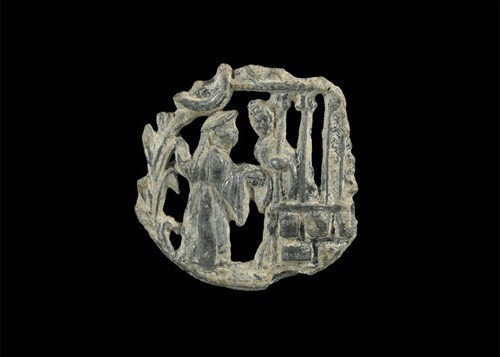 Medieval Pewter Secular Hat Badge: Circa 15th century AD. A cast lead-alloy openwork badge of discoid form depicting a courtship scene of a figure leaning out from a balcony extending a hand towards a second figure in a hat and robe wi