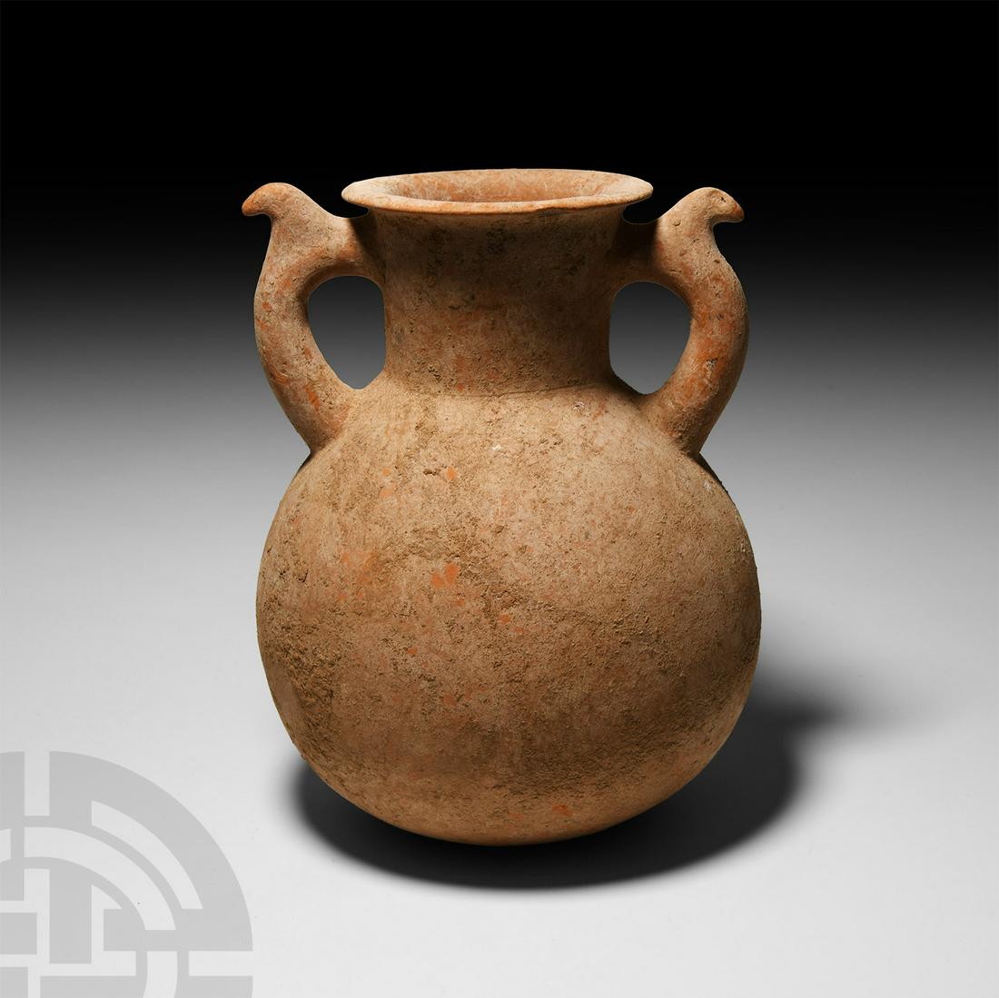 Amlash Terracotta Amphora: 2nd-1st millennium B.C. A finely modelled red terracotta amphora featuring a globular body rising from a flat base, a short neck, and a wide, flaring rim; two applied handles extending from the shoul