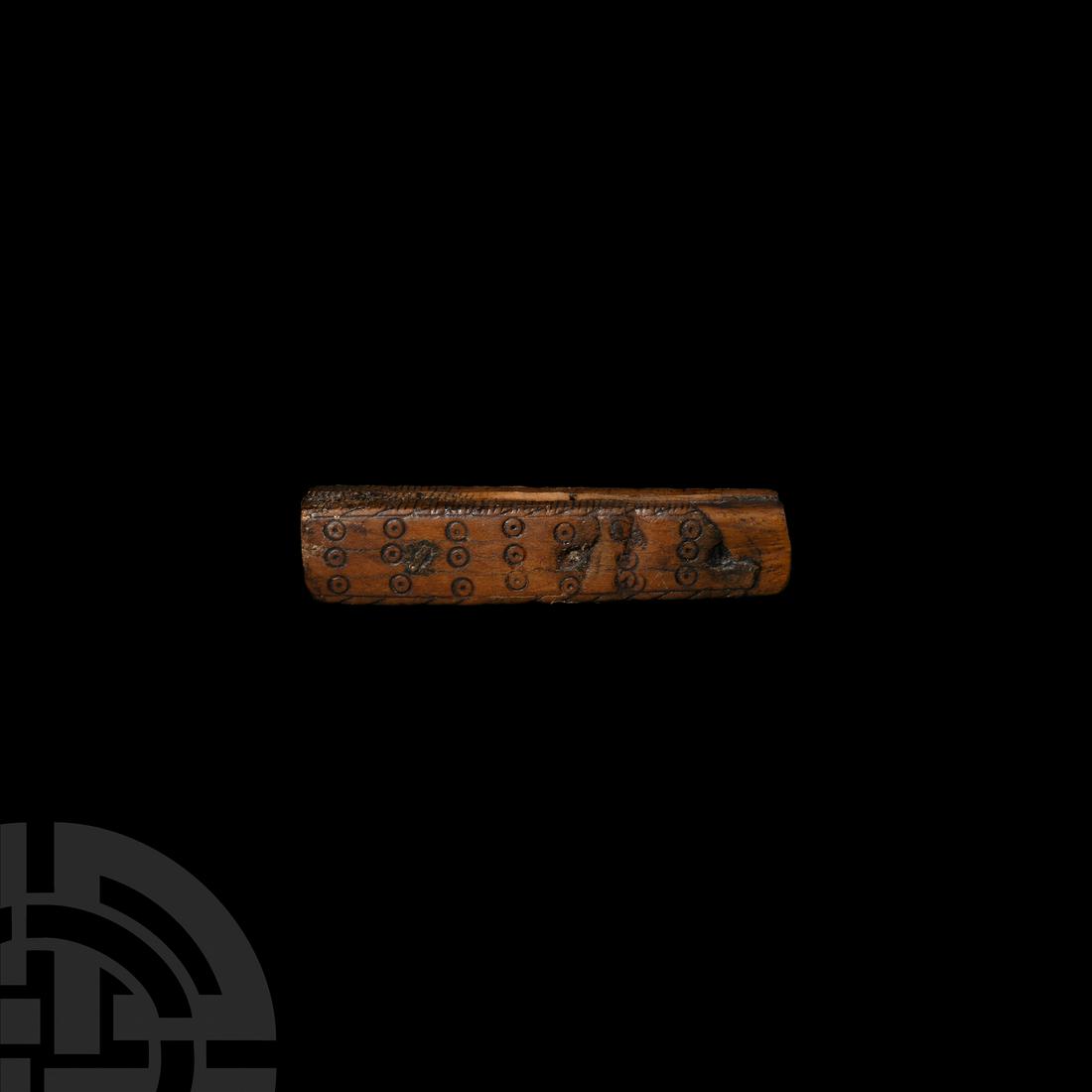 Medieval Decorated Bone Artefact: 14th-15th century A.D. A bone item, likely the hilt of a knife, composed of a slightly tapering cuboid body with a thin piece of bone sandwiched between the two halves, one face ornamented with ring-a