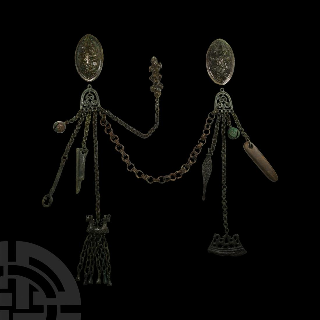 Viking Period Tortoise Brooch and Chain Set: Circa 9th-10th century A.D. A bronze female garniture comprising: two tortoise brooches each with pin-bar and catch to the reverse, one with remains of fabric; two D-shaped openwork chatelaines with s