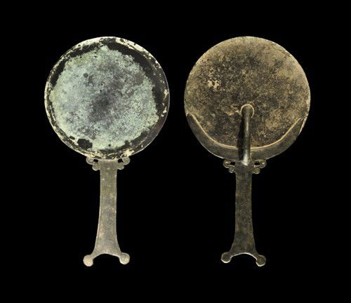Roman Bronze Handled Mirror: Circa 1st-2nd century AD and later A composite cast bronze mirror comprising a cast flat disc with polished surface; to the reverse, a round-section arched support bar attached to the crescentic frame