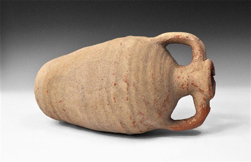 Roman Ceramic Palestinian Ribbed Ware Amphora: Circa 4th-5th century AD A short terracotta amphora with rounded base, barrel-shaped body, rounded shoulder, narrow neck and two strap handles; the surface corrugated and with calcareous accretion. Ce