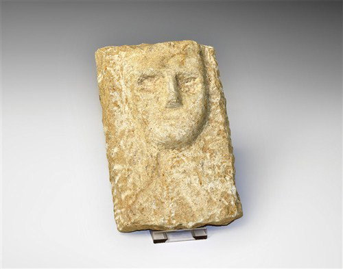 Near Eastern Limestone Figural Stele: Arabian, circa 2nd-3rd century AD A limestone stele or decorative plaque formed as a rectangular plate with a stylised human face in the upper zone, the brow ridged, nose prominent, eyes recessed and