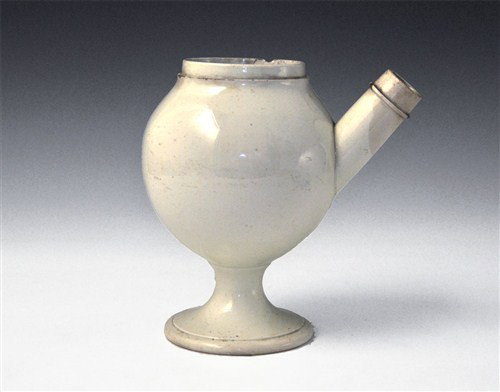 Post Medieval Ceramic Apothecary Drug Jar: Victorian, circa 19th century AD A white-glazed ceramic jar with tall pedestal base, globular body, short rim and tubular spout with collar. Ceramic, 720 grams, 21 cm (8 1/4") Property of a Sussex Gen