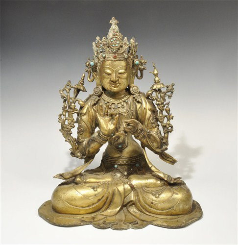 Chinese Gilt-Bronze Buddha Figurine: Circa 20th century AD or earlier A large cast gilt-bronze cross-legged Buddha figurine, the crown and jewellery embellished with turquoise and carnelian cabochon stones; the hands in attitude of bless