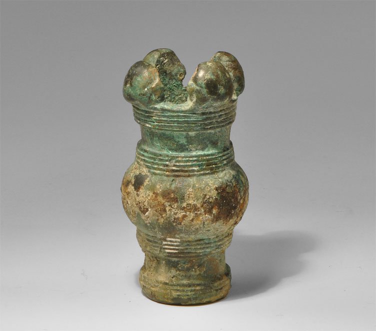 Luristan Bronze Mace Head: Circa 800 BC. A cast bronze mace head, tubular with integral transverse ribbed collars, bulbous median section and four bulbous knops to the upper rim. Bronze, 2.94 grams, 82 mm (3").