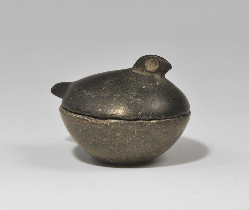 Mesopotamian Stone Bird Cosmetic Jar and Lid: 3rd millennium BC. A carved stone miniature cosmetic jar formed as a hollow hemispherical dish and shallow lid formed with a triangular head and rectangular tail; the head with drilled eyes, the tail