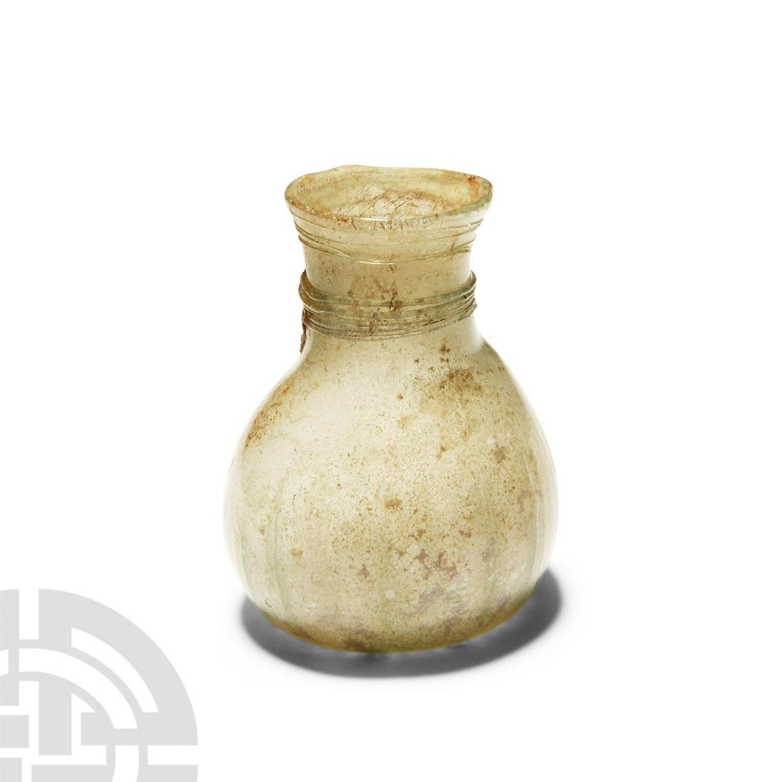 Byzantine Ribbed Glass Cosmetic Bottle with Trail: Circa 5th-6th century A.D. Globular-bodied with a cylindrical neck and everted rim, applied trails around the neck and shallow vertical ribbing rising from the base up the lower body. 15.3 grams, 57 m