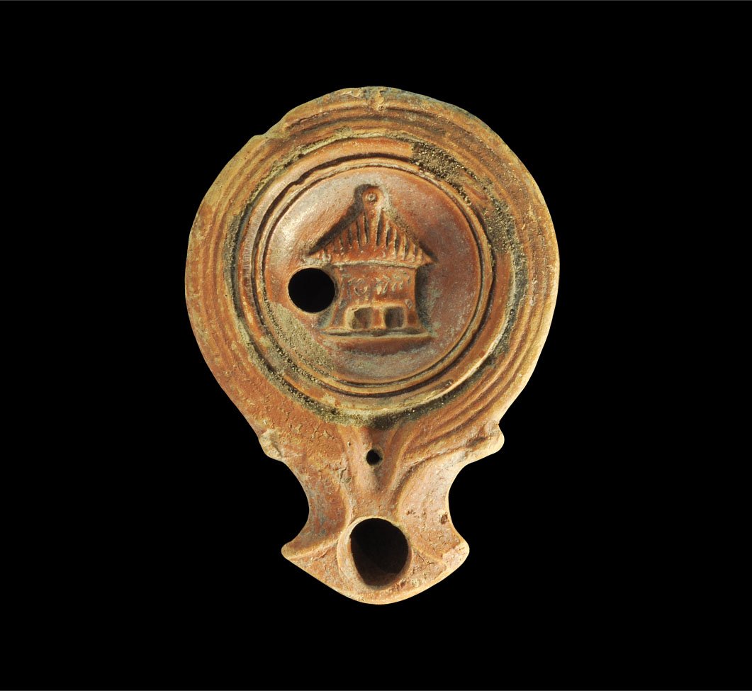 Roman Ceramic Altar Oil Lamp: Circa 1st-2nd century AD. A terracotta oil lamp with scrolled nozzle and raised image to discus of an altar. Property of a London Gentleman; acquired before 1985. 67 grams, 90 mm (3 1/2").