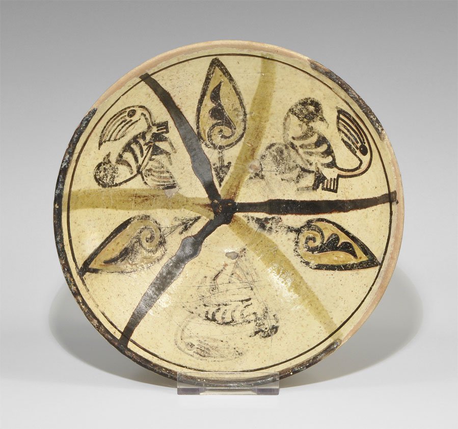 Islamic Ceramic Black Bird Bowl: An undated ceramic cream-glazed bowl, conical with tall basal ring, three birds and three leaves painted to the inner face. Property of a London collector, acquired early 1960's. Ceramic, 365 grams, 1