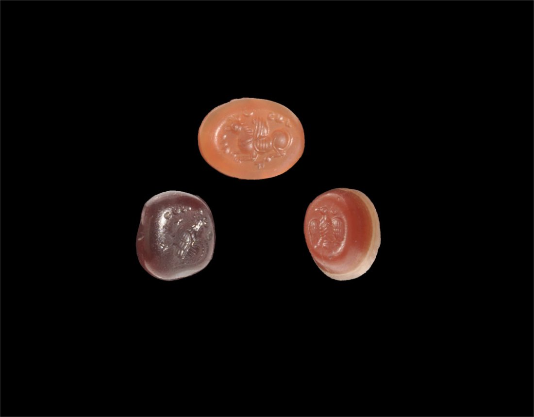 Roman Intaglio Gemstones Group: Circa 3rd century AD or later. A mixed group of stone intaglios comprising: a banded agate conical with splayed eagle motif; a hardstone elliptical with gryphon motif; a hardstone rectangular with coc