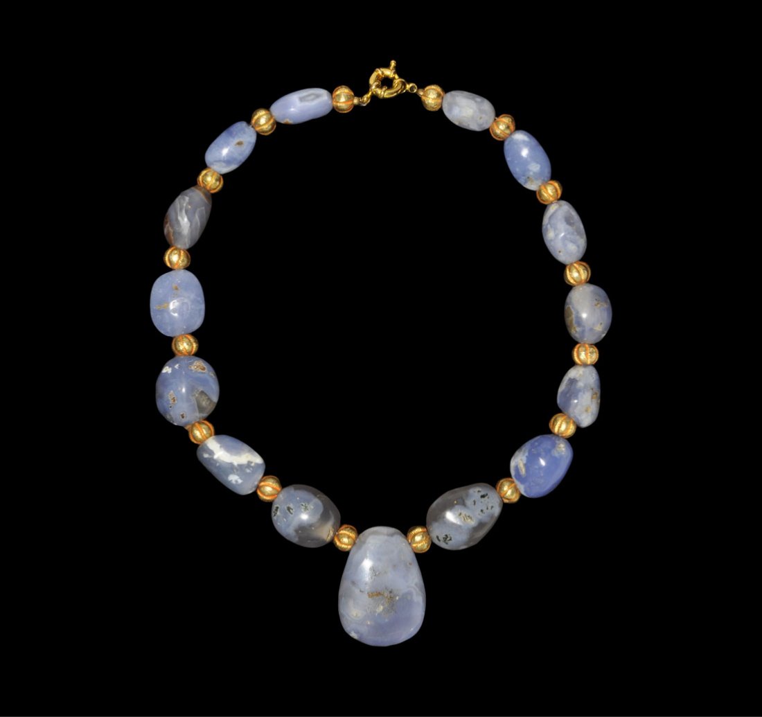 Islamic Lapis Lazuli and Gold Bead Necklace: Circa 19th-20th century AD. A restrung necklace of large biconical and globular blue chalcedony beads with gold melon bead spacers and ovoid pendant; modern clasp From an old English collection. 165 g
