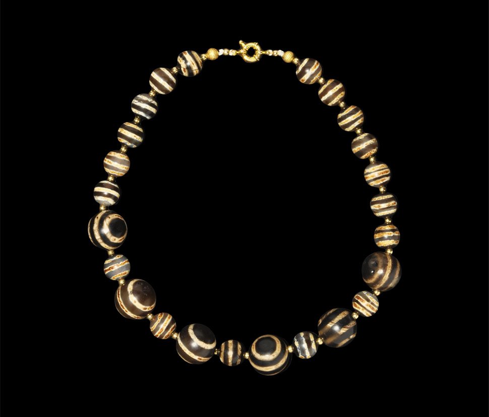 Islamic Agate Eye Bead Necklace: Circa 20th century AD. A restrung necklace composed of graduated globular stained agate 'eye' beads with gold seed bead spacers; modern clasp. UK art market, acquired prior to 1985. 149 grams, 46 cm (