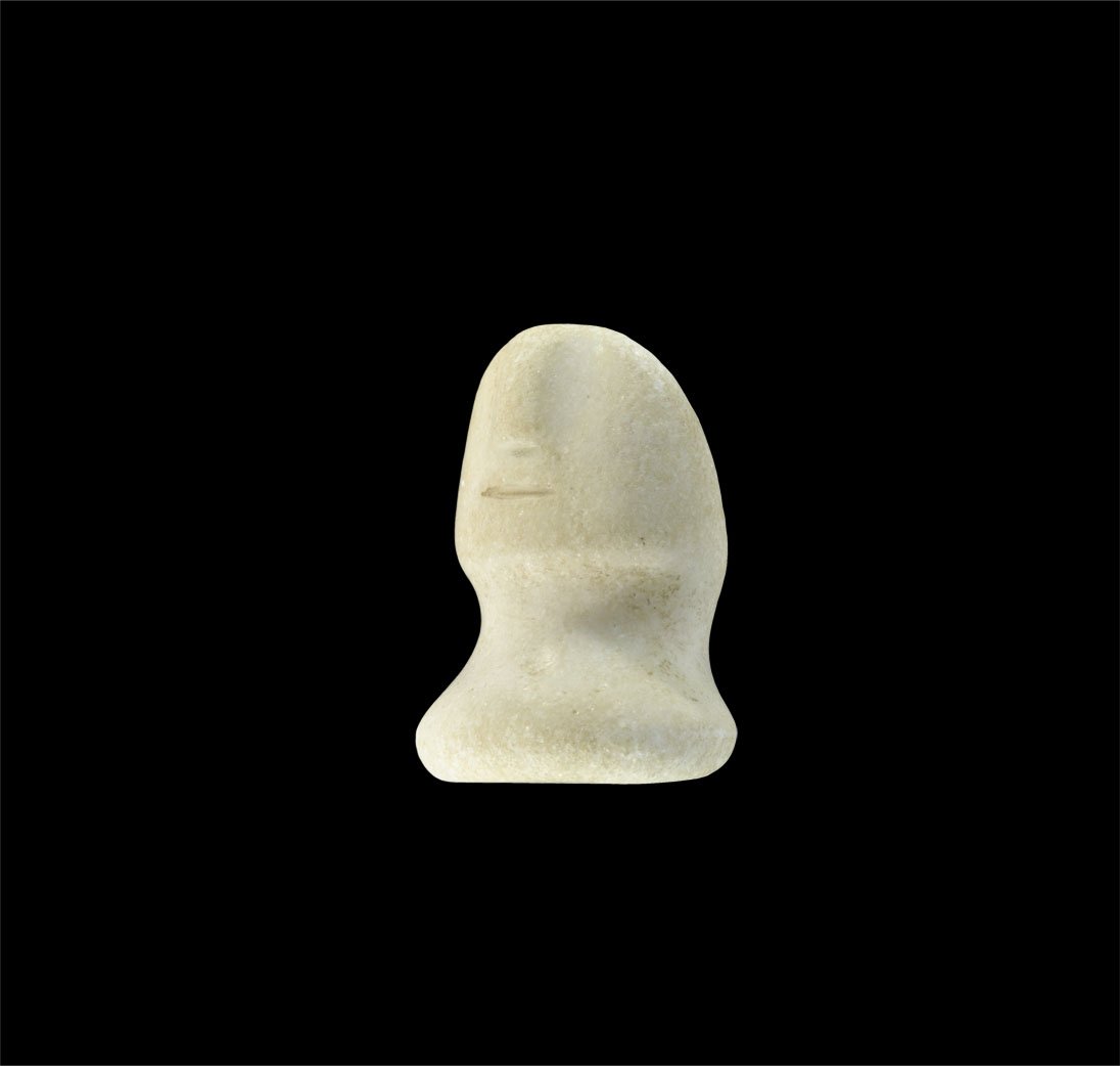 Bactrian Marble Idol Head: 3rd-1st century BC. A carved alabaster bust with discoid base and female face with elliptical mouth and rectangular nose, flat to the reverse. Acquired on the London art market in the 1980's. Stone, 2