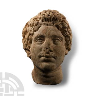 Roman Marble Head of a Germanic Warrior: 2nd-3rd century A.D. Modelled naturalistically in the round, directing his gaze upwards left, the eyes with sculpted pupils originally decorated with stone insertions, his face framed by voluminous