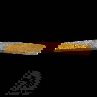 Viking Age or Earlier Hacked Gold Trade Ingot: Circa 10th century A.D. or earlier. A slightly bent irregular bar of hacked gold with rectangular cross-section, showing evidence of compression and fracture to each end, some subtle transverse lines