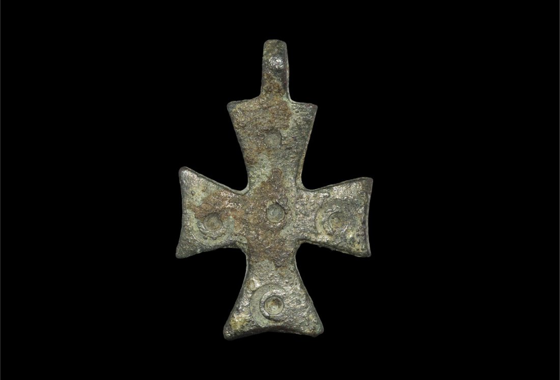 Byzantine Bronze Cross Pendant: Circa 10th century AD. A small cast bronze cross pendant, the centre and arms with stamped roundel decoration; integral loop for suspension. Ex Yagiello collection; aquired on the London and Paris art