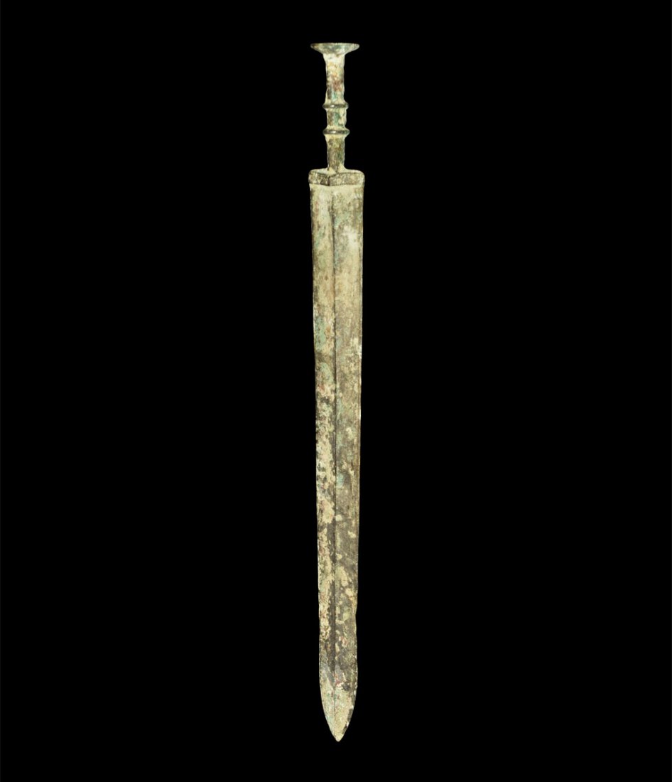 Bronze Age Luristan Bronze Short Sword: Luristan, circa 1500–500 BC. A cast bronze short sword with parallel-sided blade, integral guard and hilt; the blade lozenge-section with median rib and rectangular guard above; the grip columnar wi