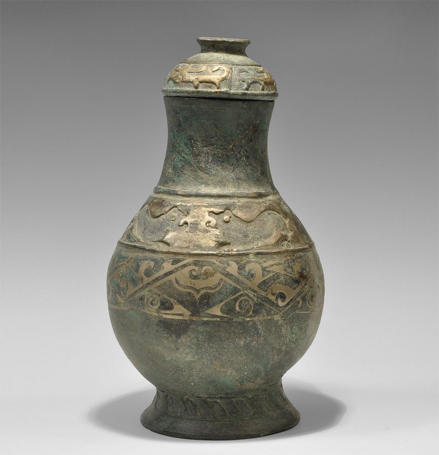 Chinese Han Dynasty Style Bronze Lidded Vessel: A large undated cast bronze vessel with conical base, globular nody and tall neck; to the base a slashed band, with gilt-bronze scrolled patterns to the body and shoulder; the lid a hemispherical cap 
