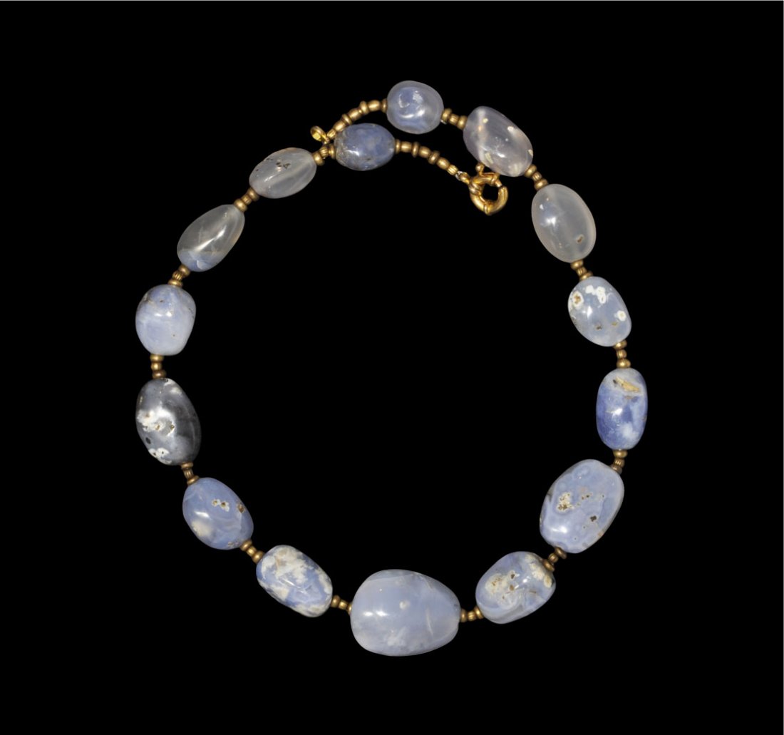 Indian Blue Chalcedony and Gilded Spacer Bead Necklace: Circa 19th century AD. A restrung necklace of blue chalcedony elliptical beads and gilded annular and melon spacer beads; modern clasp. London collection; acquired in the 1950's. 153 grams, 52 cm (20
