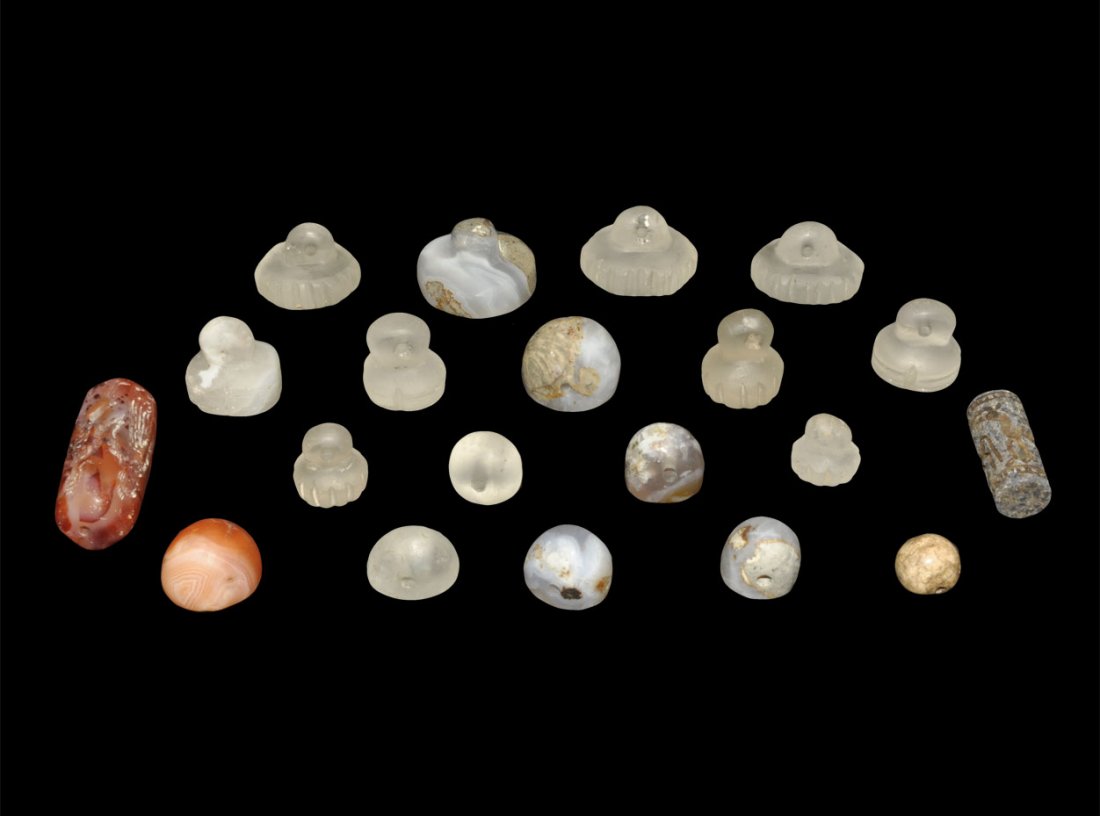 Near Eastern Crystal and Stone Seals Group: 20th century AD or earlier. A mixed group of stamp seals comprising: ten crystal with dentilled edge and pierced lug to the reverse; two crustal plano-convex; two cylindrical; one carnelian plano-conv