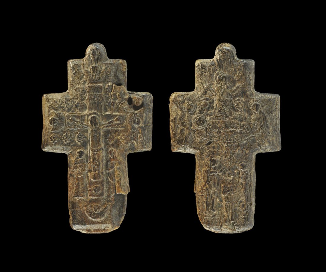 Byzantine Carved Bone Cross Pendant: Circa 7th-10th century AD. A very rare bone cruciform pendant; to one side, a carved secene of the Crucifixion, including Christ on the cross, flanked by two female figures, bordered with styslised fl