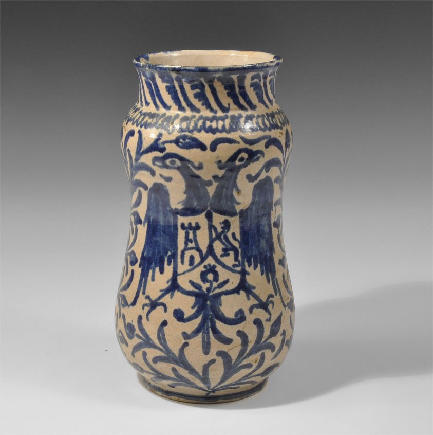 Islamic Ottoman Ceramic Blue-Glazed Vase: Circa 19th century AD. A tall blue-glazed ceramic vase with double-bulb profile and rolled rim; the design painted in blue, a field of foliage bearing a double-headed eagle motif with heraldic shield 
