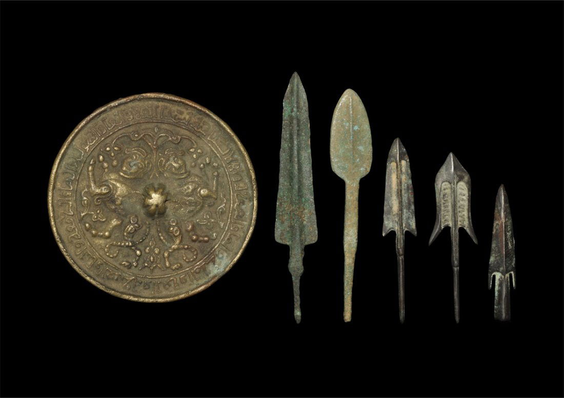Chinese Style Mirror and Arrowhead Group: A mixed group of undated bronze items comprising: a small discoid miror with pierced lug to the reverse, Arabic text surrounding; two leaf-shaped tanged arrowheads; one lozenge-section barbed and sock