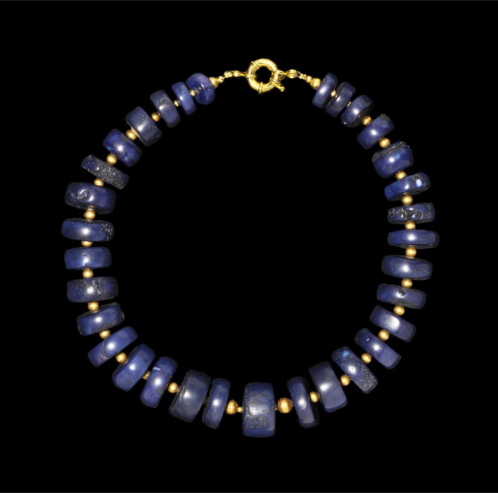 Islamic Gold and Blue Dyed Coral Bead Necklace: Circa 20th century AD. A restrung necklace of blue-dyed 'bamboo coral' disc beads with gold seed bead spacers; modern clasp. London collection; acquired in the 1950's. Coral and gold, 307 grams, 52 cm