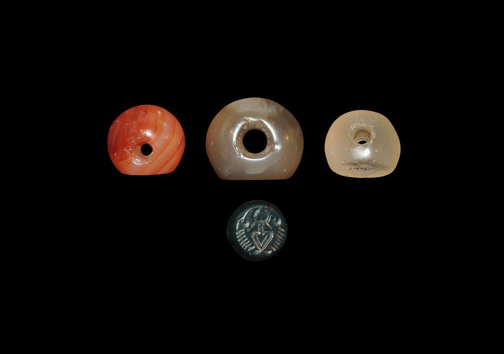Near Eastern Sassanian Stamp Seal Group: Sassanian Empire, 224-651 AD. A mixed group of carved stone stamp seals comprising: one olive hardstone, ear of wheat motif; one carnelian, bird motif; one black hardstone, geometric motif; one crysta