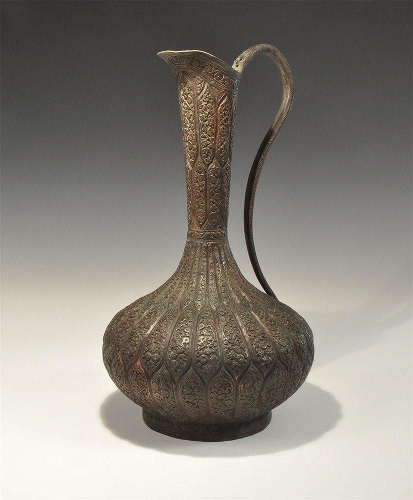 Near Eastern Turkish Bronze Repousse Ewer: Circa 19th century AD or later. A bronze ewer comprising a low basal rim, bulbous body, tall funicular neck, shallow spout and gravefully curved handle to the rear; the surface with interlocking hexag