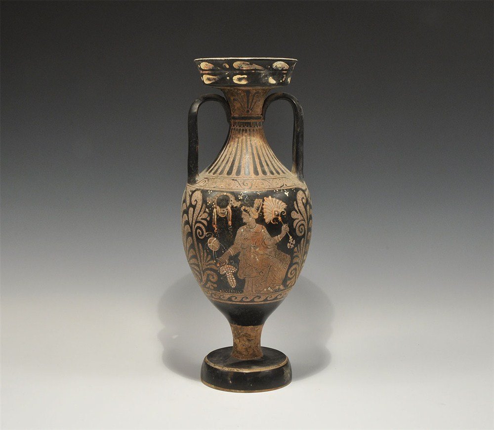 Greek Style Red Figure Amphora: A Grand Tour Attic-style amphora with pedestal base, the mammiform body depicting a draped female, seated, turning towards her right, a fan in her left hand, flanked by palmettes, and two young males,