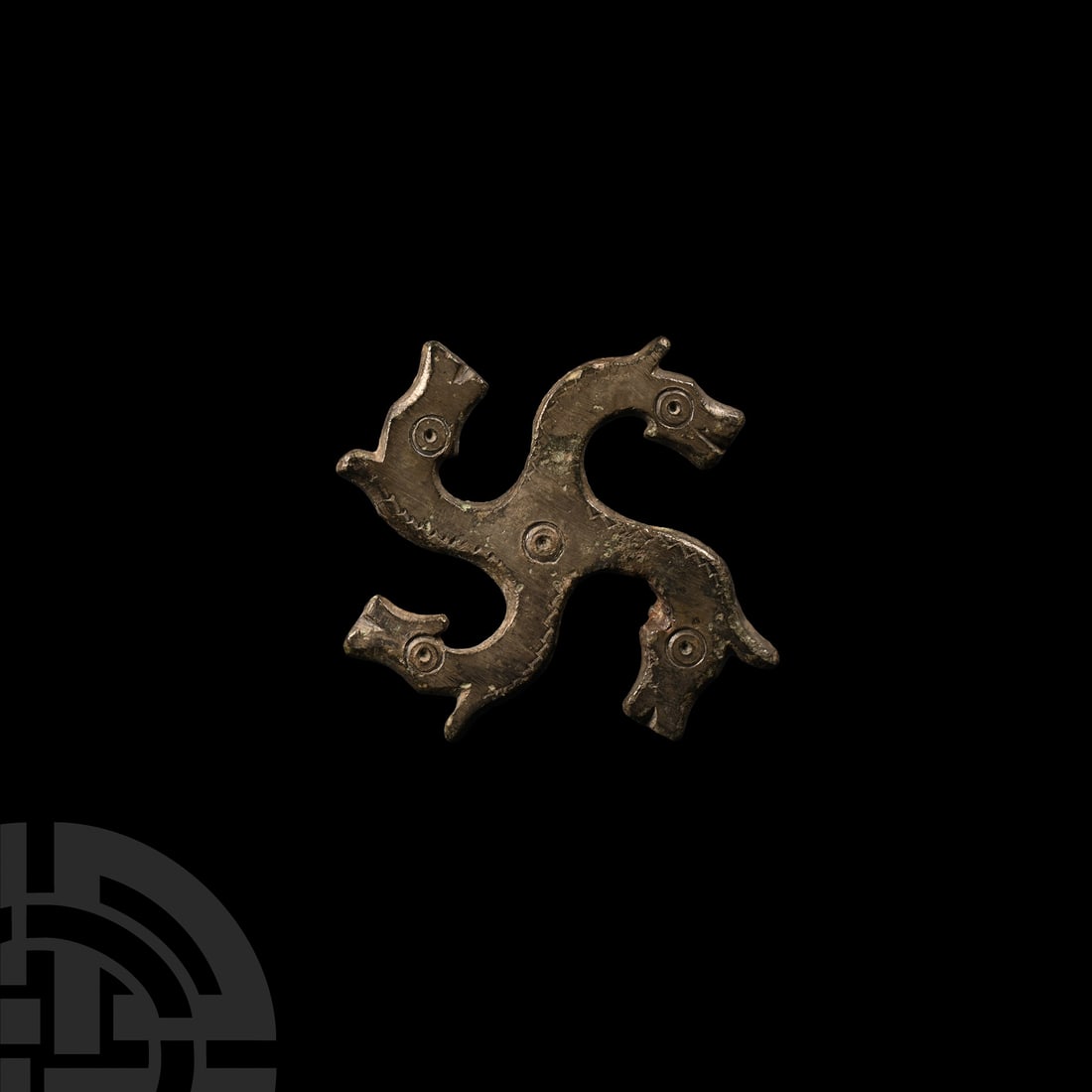 Roman Bronze Horse Head Whorl Brooch: 3rd-4th century A.D.. Swastika-shaped fibula with horse-head decoration, each head with punched ring-and-dot eye, a similar motif to the centre. Cf. Petcu, R., ‘Swastika-shaped fibulae with horse-he