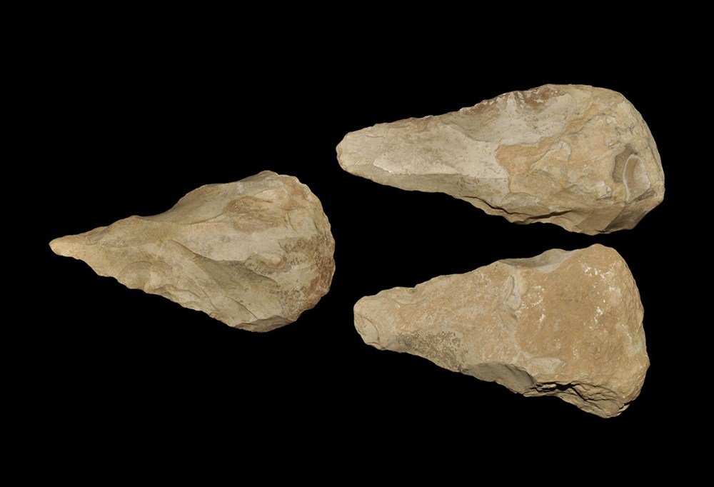 Stone Age Jordan Bifacial Chert Hand Axe Group: Palaeolithic, circa 400,000-200,000 BP A group of three large bifacial core hand axes in a pale, patinated chert, each finely knapped with straight edges tapering to points, with some original cortex