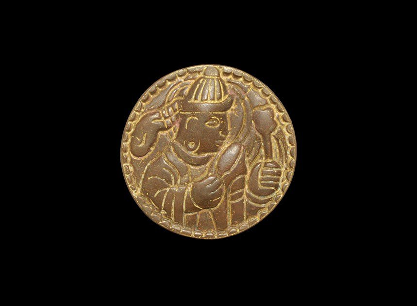 Near Eastern Sassanian Copper Disc Mount: An undated archaistic cast bronze disc mount depicting a figure in loose robes and tall conical headgear holding a mace in his raised left hand. Property of a London collector, acquired early 1960's. 