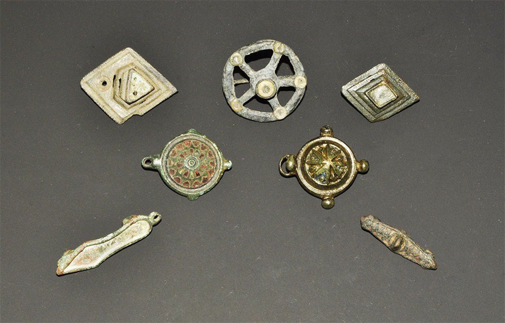 Roman Bronze Brooch Group: 1st-2nd century AD. A mixed group of bronze brooches comprising: one equal-ended with enamel design; one lozenge type with raised enamel triangle; one wheel type with enamel discs; one sandal type wit