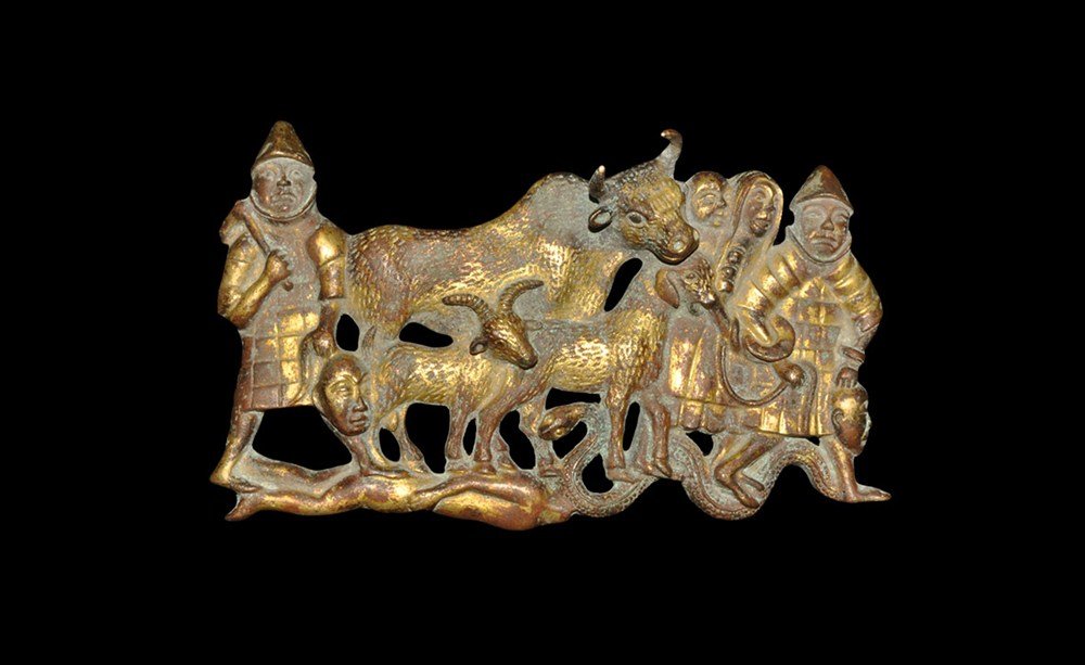 Chinese Style Gilt Bronze Figural Plaque: An undated archaistic Chinese style gilt-bronze plaque, hollow to the reverse, depicting a military procession comprising: an advancing male in armour holding a severed head in his left hand and priso
