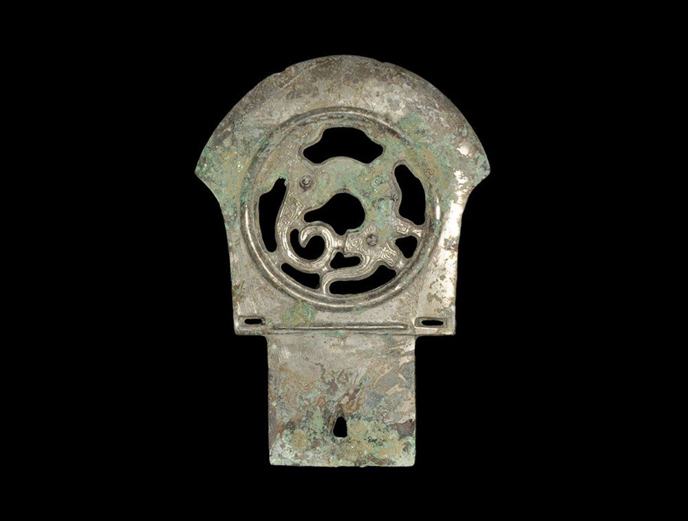 Chinese Zhou Dynasty Bronze Axehead: Zhou Dynasty 1046–256 BC. A cast bronze axedhead with rectangular plaque and peltoid blade; the plaque with triangular hole and reserved characters to one face; the blade with central openwork panel