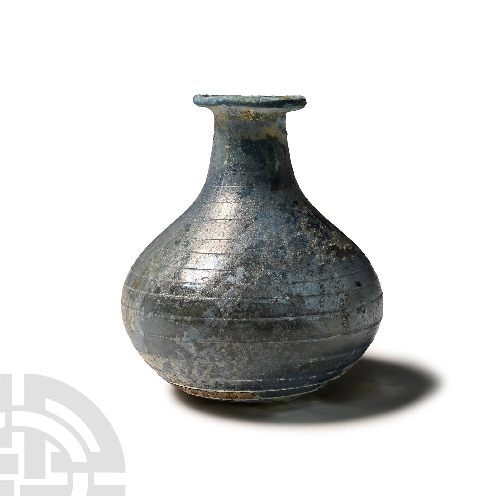 Roman Blue Glass Flask with Trail: 3rd-4th century A.D.. Piriform in profile with slight dimple to base, squat body, tubular neck with flared and rolled mouth; fine applied spiral trail from shoulder to base. Cf. Whitehouse, D., Roman