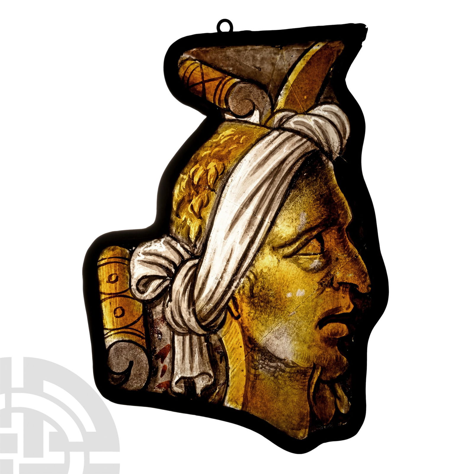 Renaissance Stained Glass Panel of a Grotesque Head in Profile: Northern France, probably Champagne, circa 1540 A.D.. Figural panel with profile head wearing a draped fabric covering knotted at the rear, the eyes cast upwards and mouth agape, with wispy facial hai