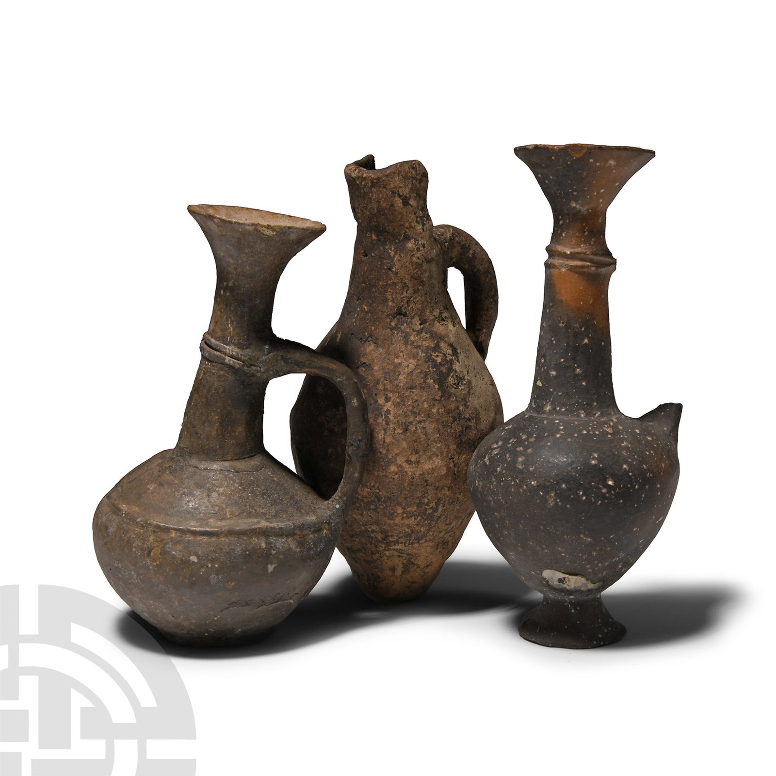 Cypriot Terracotta Flask Group: Middle-Late Bronze Age, 2000-1200 B.C.. Comprising: biconvex juglet with loop handle and U-shaped lip; two with trumpet-shaped mouth and carinated body, strap handle (one absent). 322 grams total, 11.