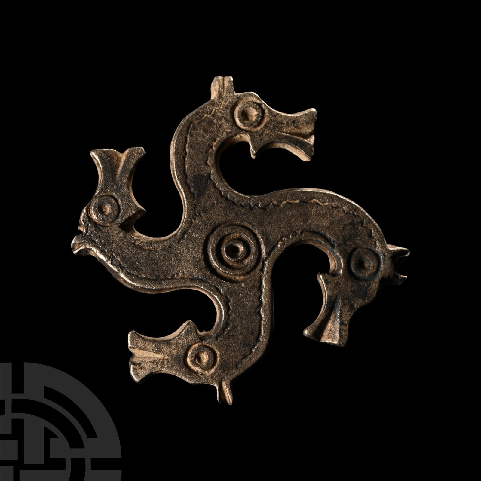 Roman Silver Horse Head Whorl Brooch: 3rd-4th century A.D.. A swastika-shaped fibula with horse-head decoration, each head with punched ring-and-dot eye, a similar motif to the centre, catchplate and pin hinge to verso. Cf. Petcu, R., ‘