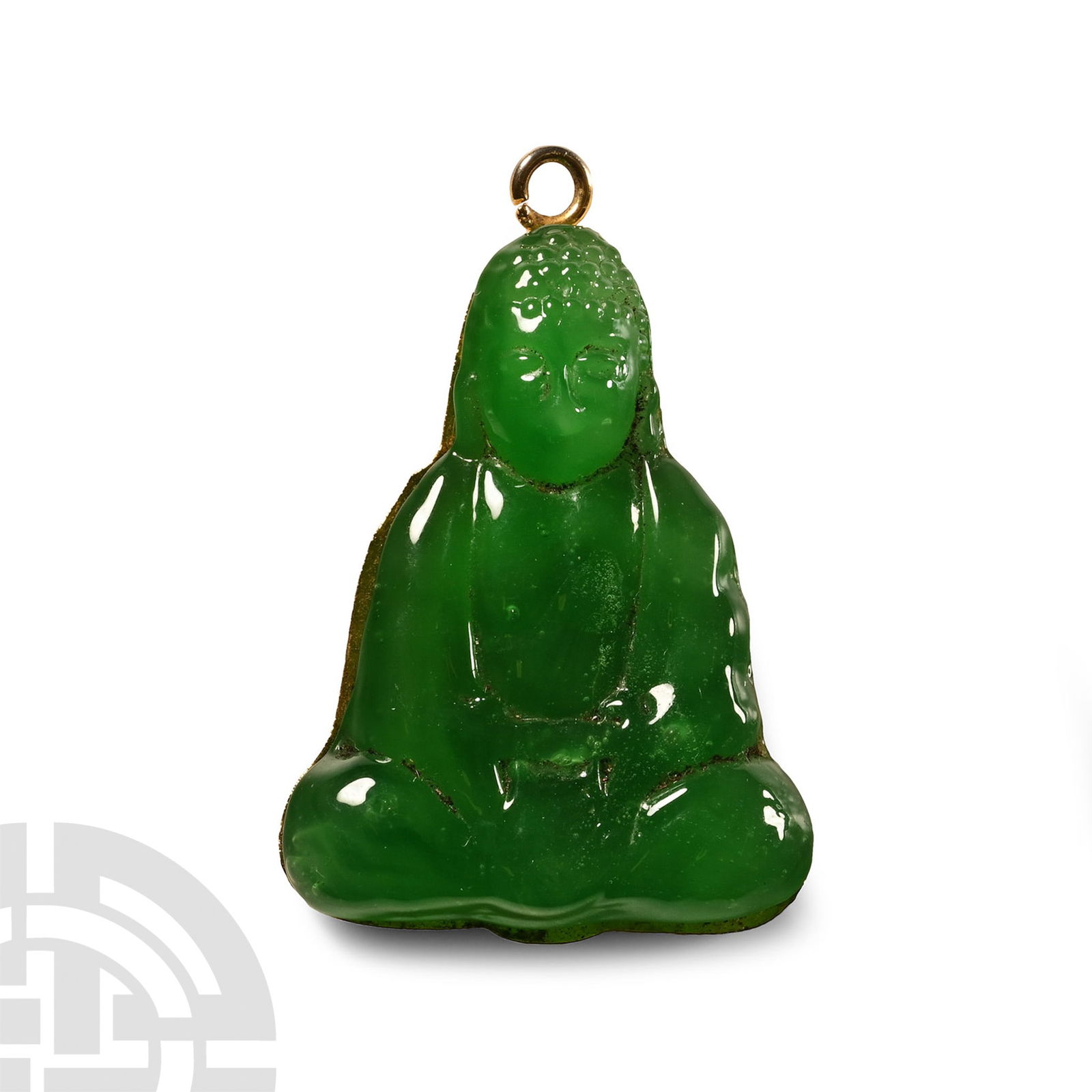Jade-Coloured Glass Seated Buddha Pendant: 19th-20th century A.D.. Modelled in the half-round, Buddha sitting cross-legged with hands folded in his lap; loop above. 8.78 grams, 40 mm (1 1/2 in.). with a London, UK gallery, 1971-early 2000s. [N