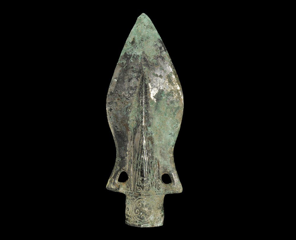Chinese Style Bronze Spearhead: An undated archaistic bronze socketed spearhead in Zhou Dynasty, circa 800-500 BC style, the lanceolate blade with decorated central ridge, the socket decorated with scroll and circle pattern, a loop 