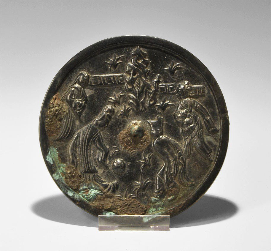 Chinese Style Bronze Mirror with Cuju Players: An undated archaistic cast-bronze disc mirror in Han Dynasty, 206 BC-220 AD style, with one tinned and polished surface; to the reverse, a central pierced lug within a scene depicting four men playing